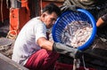 A fisherman taking the fish off a boat at Ban Bang Saray Fish Bridge, Thailand