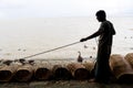 Fisherman taking preparation for fishing by cage and rope on the riverbank