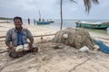 A fisherman tends to his nets on the west coast beach on Delft Island in the Jaffna region of Sri Lanka. Royalty Free Stock Photo