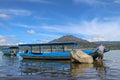 A fisherman from Terunyan village prepares a boat for fishing. A man unleashes a fishing boat on Lake Batur. Mount Batur or Gunung Royalty Free Stock Photo