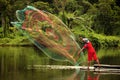 Fisherman throwing fishing net on the lake