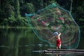 Fisherman throwing fishing net on the lake