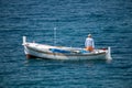 Fisherman in traditional wooden boat at sea