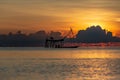 Fisherman on a traditional wooden boat during sunrise