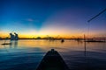 Fisherman on a traditional wooden boat during sunrise