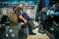 Fisherman tries on rubber boots in fishing shop Royalty Free Stock Photo