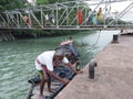 Fisherman trying to anchor boat near jetty