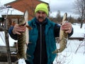 Fisherman with two pike in his hands