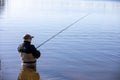 Fisherman in waders catches pike in the lake Royalty Free Stock Photo