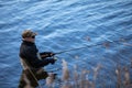 Fisherman in waders catches pike in the lake