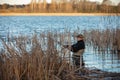 Fisherman in waders catches pike in the lake Royalty Free Stock Photo