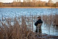 Fisherman in waders catches pike in the lake Royalty Free Stock Photo