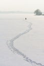 A Fisherman Walking on the Icy Lake in Search for a Good Fishing Spot Royalty Free Stock Photo