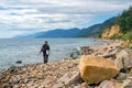 The fisherman walks along the shore of a large lake