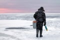 A fisherman walks on the ice with a drill. Winter fishing. Royalty Free Stock Photo