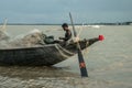 A fisherman was busy to repair his fishing net on ride a boat.