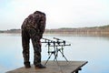 Fisherman watches feeders on rod pod with electronic bite alarms