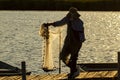 An asian fisherman carrying a cast net at sunset Royalty Free Stock Photo