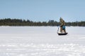 Fisherman in the winter, drilling the ice winter fishing