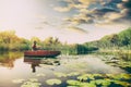 Fisherman in wooden boat with fishing rod Royalty Free Stock Photo