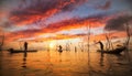 Fisherman working with net on the boat and sunset background