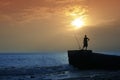 Fishermen on the beach in the evening against the sunset