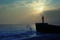 Fishermen on the beach in the evening against the sunset