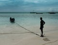 Fishermen in boat and man on the fishing vallage shore at sunset