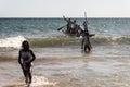 Fishermen in a canoe into the sea for delivery of Iemanja gifts at Boca do Rio beach