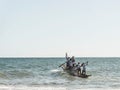 Fishermen in a canoe into the sea for delivery of Iemanja gifts at Boca do Rio beach