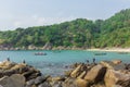 Fishermen catching fish on the rocky tropical beach in Thailand. Sunny day