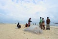 Fishermen clean fish net at seashore Royalty Free Stock Photo