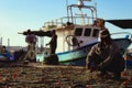 Fishermen collecting and cleaning fishing nets after the fresh catch of the day