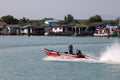 Fishermen drive a small boat along the village and river near th