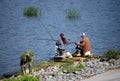 Fishermen early in the morning sit on the stony river bank and catch fish