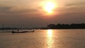 Fishermen fishing in the bright sunset sky with a reflection of the sun on the river bank. Royalty Free Stock Photo