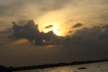 Fishermen fishing in the bright sunset sky with a reflection of the sun on the river bank. Royalty Free Stock Photo