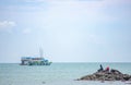 Fishermen fishing on rocks Background boats parked in the sea at krabi , Thailand.12 October 2020