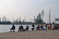 Fishermen fishing with a rod at the pier in the seaport on a warm windless autumn day