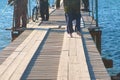 Fishermen with fishing rods on a wooden pier coastal sea town. Royalty Free Stock Photo