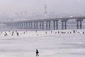 Fishermen are ice fishing on the Dnieper river near Kiev, a bridge on a background Royalty Free Stock Photo