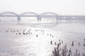 Fishermen are ice fishing on the Dnieper river near Kiev, a bridge on a background Royalty Free Stock Photo