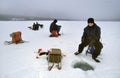 Fishermen ice fishing on a frozen lake in winter Royalty Free Stock Photo