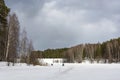 Fishermen on the ice of a small river on a cloudy spring day Royalty Free Stock Photo