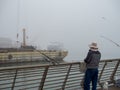 Fishermen on industrial pier on foggy day Royalty Free Stock Photo