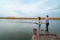 fishermen. little girl and boy fish on a fishing rod standing on a wooden bridge Royalty Free Stock Photo