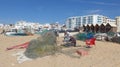 Fishermen mending their nets. At the long, wide, fine sandy fisherman beach of Armacao de Pera, Algarve, Portugal