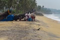 Fishermen near boat on the beach in Kovalam