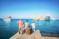 Fishermen near entrance into Mandraki harbor in City of Rhodes