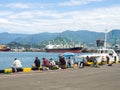 Fishermen in the port of Batumi. Fisherman on the Black Sea. Hobby. Industrial zone. Fishing from the pier. rods Royalty Free Stock Photo